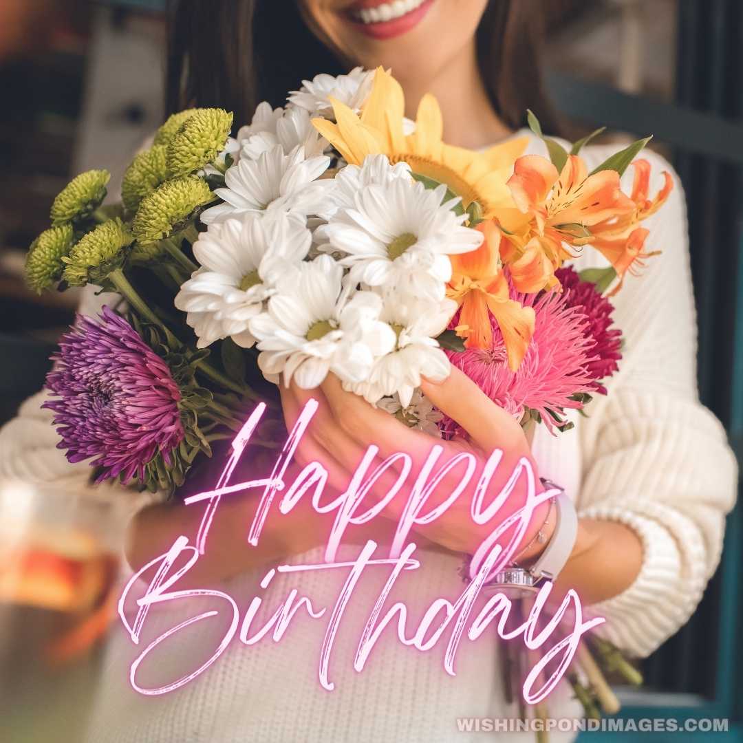 Partial view of a smiling young woman holding a colorful bouquet of various flowers in the Cafe - Ha